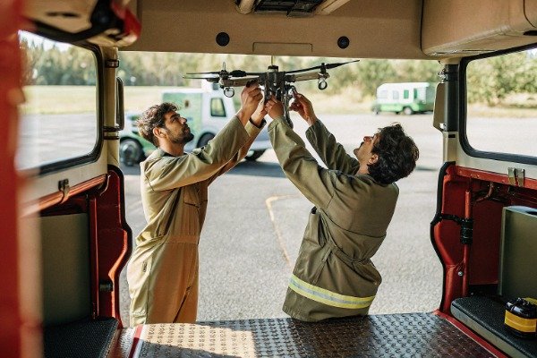 Drone preparation Two technicians preparing drone inside vehicle (ID#4)