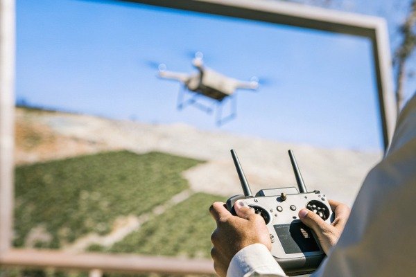 Drone remote control Operator controlling drone with remote in outdoor setting (ID#5)