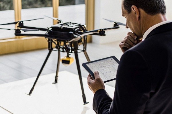 Procurement manager inspecting firefighting drone indoors (ID#1)