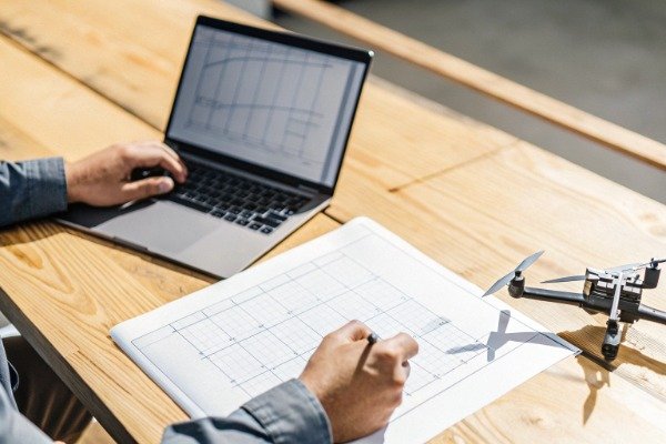 Manager reviewing drone report and technical data (ID#1)