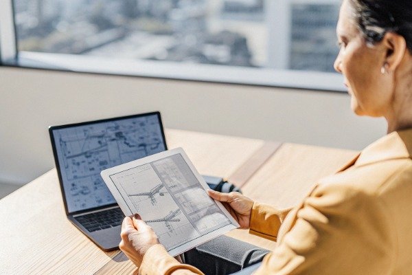 Manager reviewing contract with digital tablet and laptop (ID#1)