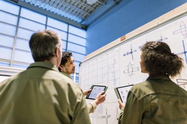 Drone engineers discussing plans in manufacturing facility (ID#2)