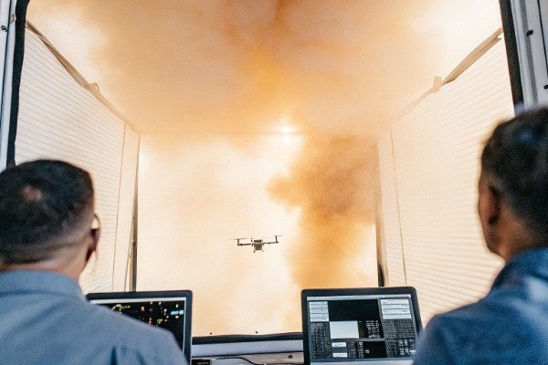 اختبار الطائرات بدون طيار طائرة بدون طيار تحلق داخل منشأة الاختبار مع دخان (ID#2)