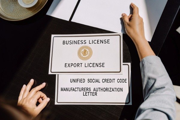 Business license and export authorization documents on table (ID#2)