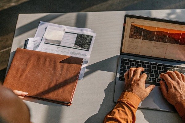 Research process with laptop and documents on table (ID#2)