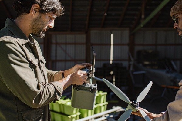 Drone maintenance Technician handling drone components in workshop (ID#3)