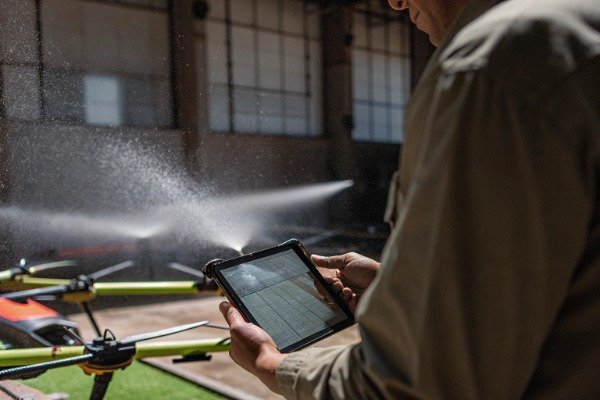 Drone water test Technician testing drone with water spray indoors (ID#3)