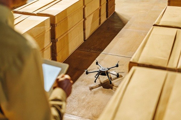 Inspector checking shipment equipment with drone in warehouse (ID#3)