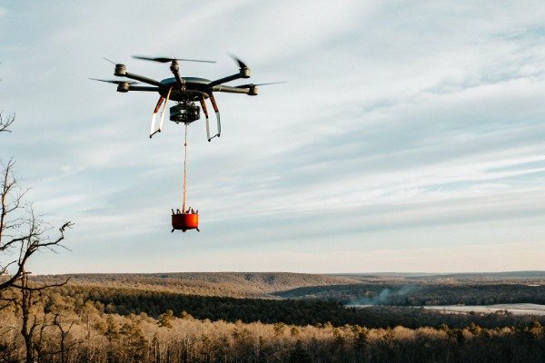 Firefighting drone Heavy-lift firefighting drone hovering over forest (ID#4)