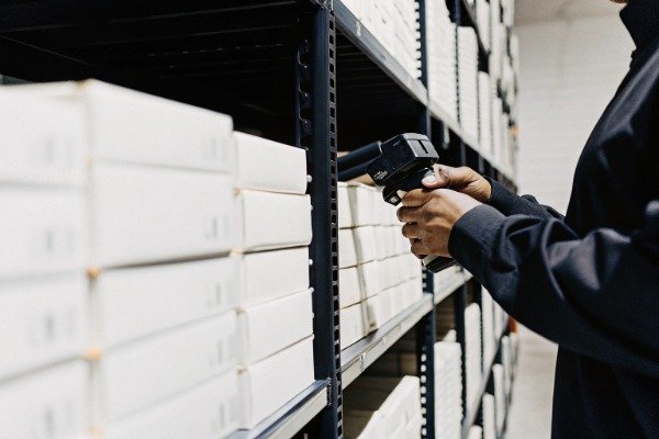 Warehouse Scanning Person scanning boxes in organized warehouse section (ID#5)