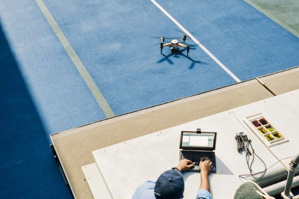 Drone test site Operator controlling drone on blue track field (ID#5)