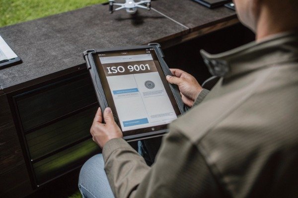 Professional procurement specialist scrutinizing ISO 9001 certificate (ID#5)