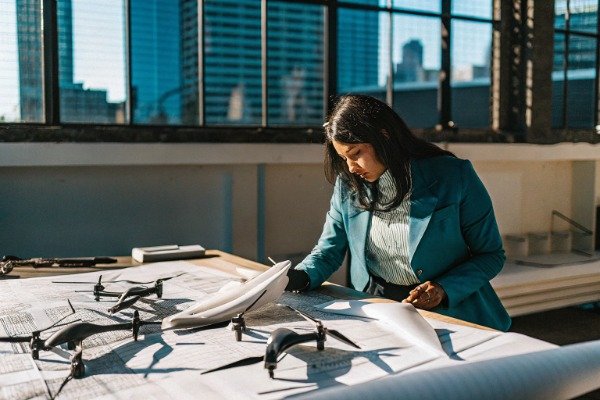 Procurement manager planning drone inventory at desk (ID#1)