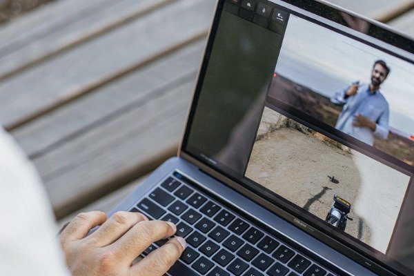 Video conference Close-up of laptop showing video conference and drone footage (ID#2)