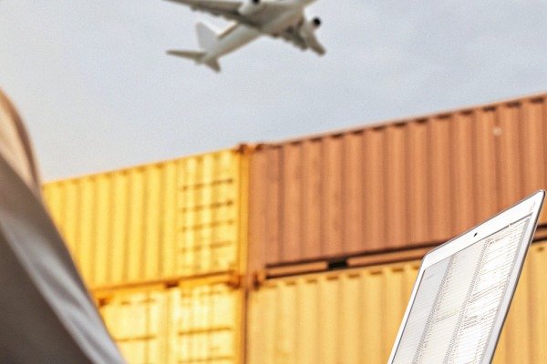 لوجستيات الشحن الجوي طائرة تحلق فوق حاويات الشحن مع كمبيوتر محمول (ID#3)