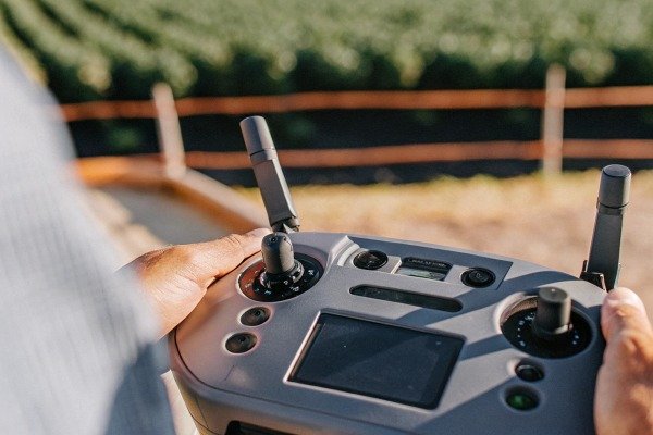 Hands operating drone remote controller outdoors (ID#4)