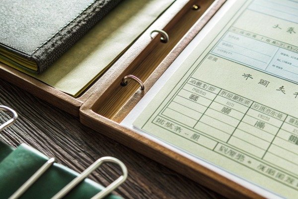 Close-up of a binder with documents and a notebook. (ID#3)