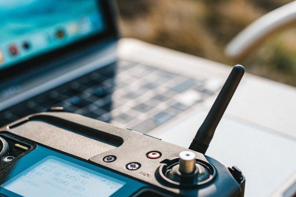 Drone controller and laptop Close-up of a drone remote controller with a laptop in the background (ID#3)