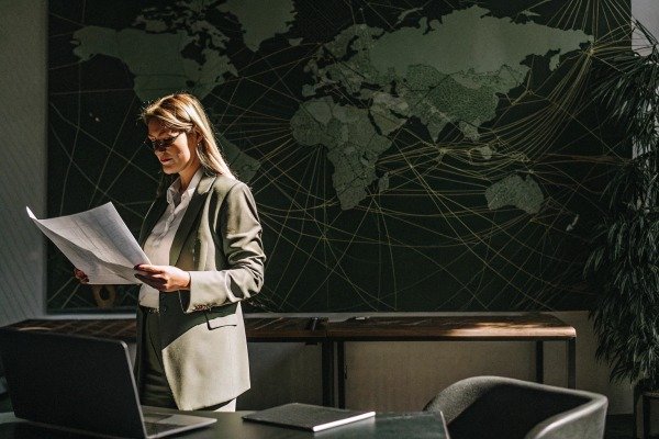 Studying map Woman studying map in office with world map background (ID#5)