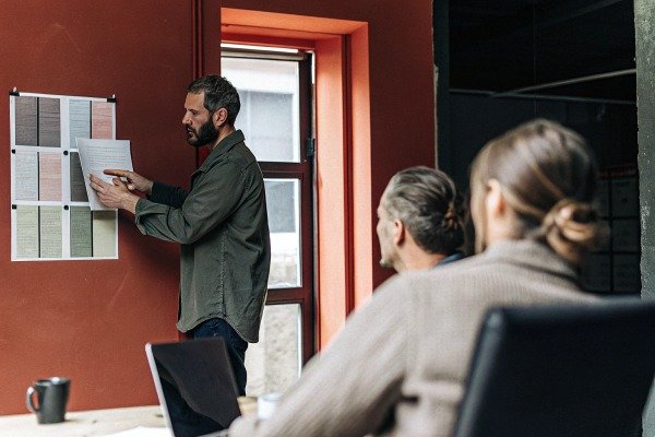 Man presenting documents to colleagues (ID#3)