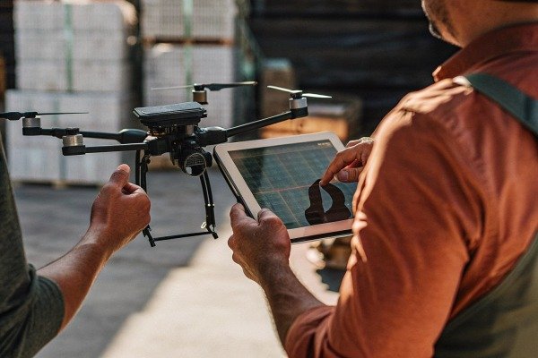 Man controlling drone with tablet indoors (ID#2)