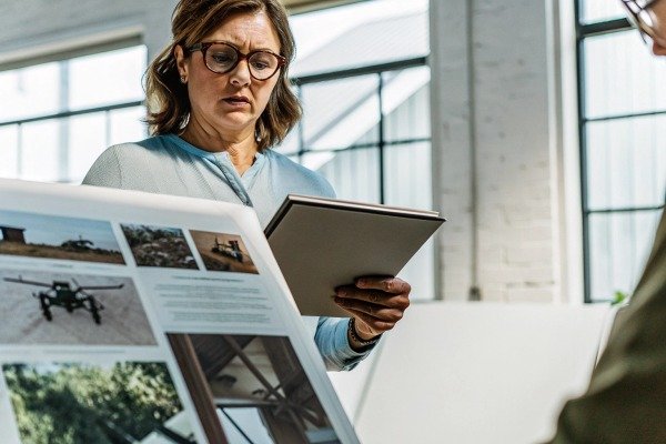 Woman reviewing drone brochure with tablet (ID#1)