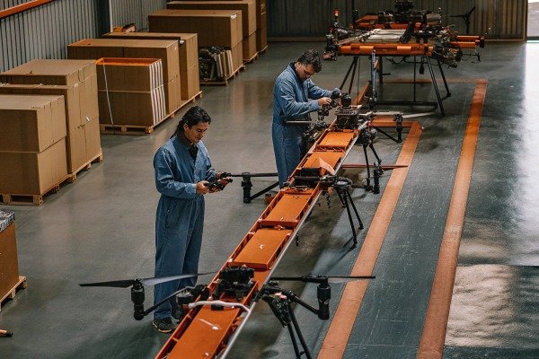 Workers assembling drones on factory line (ID#2)