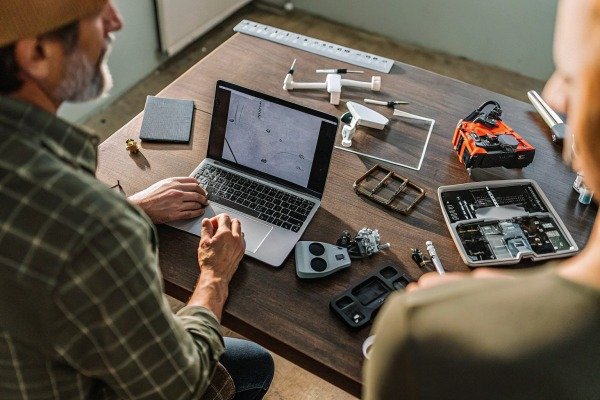 People working on drone parts with laptop (ID#5)