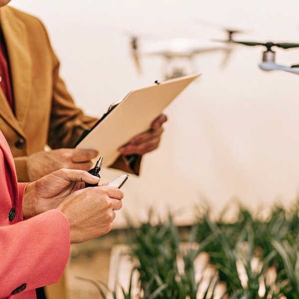 People holding clipboard and pen near drone (ID#1)