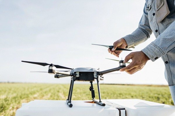 Person adjusting drone propeller outdoors (ID#2)