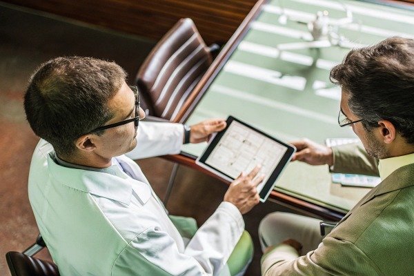 Two professionals reviewing data on tablet (ID#4)