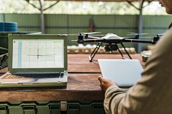 Drone setup Drone and laptop on table with person holding tablet (ID#4)