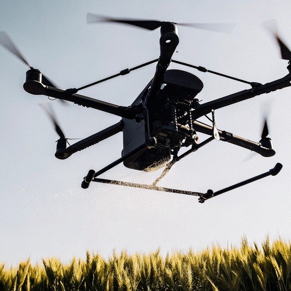 Drone spraying crops over field at sunset (ID#1)