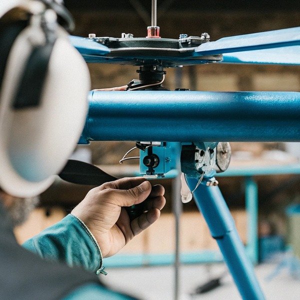 Technician adjusting drone rotor mechanism (ID#1)