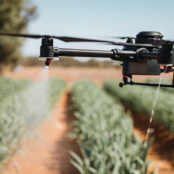 Drohne beim Sprühen von Pflanzen auf einem Feld (ID#1)