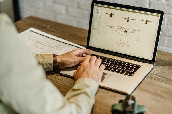Person working on drone design on laptop (ID#3)