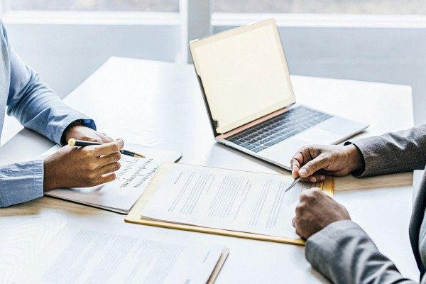 Business meeting with documents and laptop (ID#3)