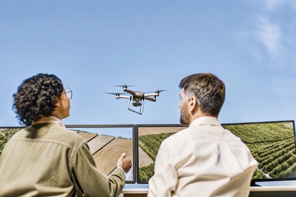 Two people monitoring drone flight on screens (ID#4)