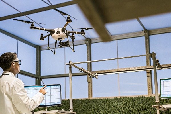 Scientist controlling drone indoors with computer (ID#3)