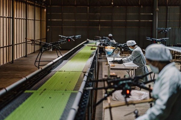خط تجميع الطائرات بدون طيار Workers inspecting drones on assembly line (ID#2)