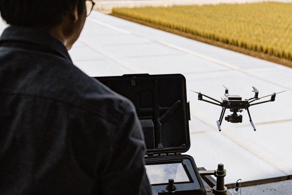 التحكم في الطائرات بدون طيار Operator controlling drone in agricultural field (ID#4)