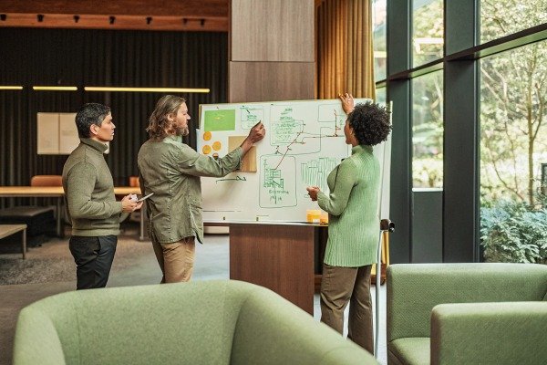 Team collaborating on whiteboard strategy (ID#4)