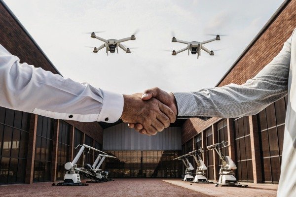 Business deal Business handshake with drones flying overhead (ID#4)
