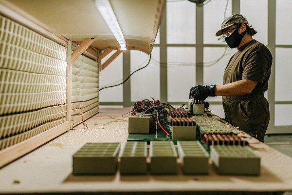 Worker assembling batteries with mask and gloves (ID#3)