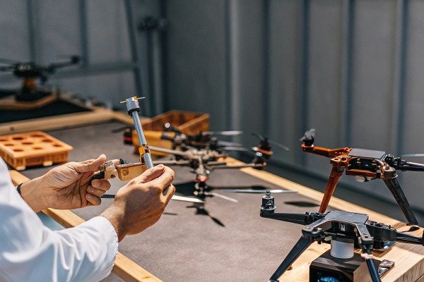 Person assembling drone parts on table (ID#4)