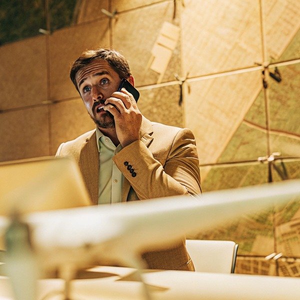 Man talking on phone with model airplane (ID#1)