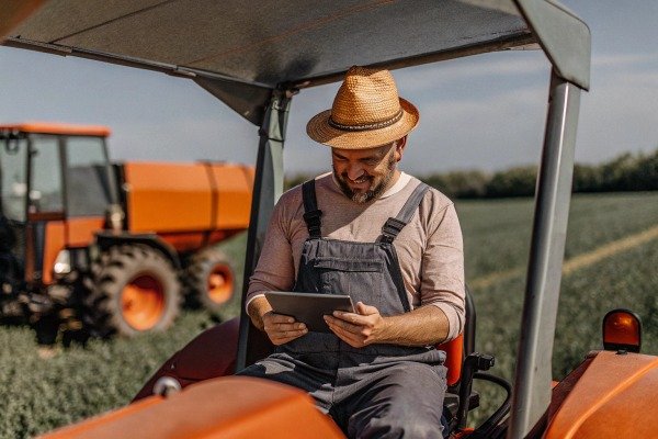 Farmer using tablet on tractor in field (ID#2)