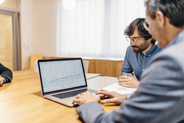 Business meeting analyzing data on laptop screen (ID#4)