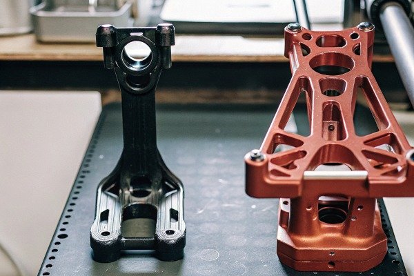 Metal drone parts on black workbench (ID#5)