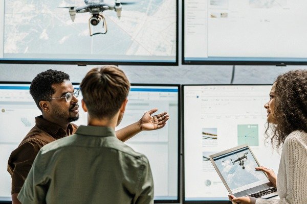 Team discussing drone data on screens (ID#4)